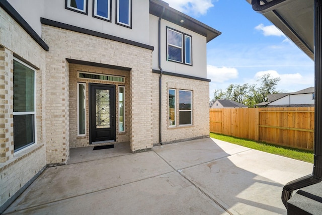 view of exterior entry featuring a patio area