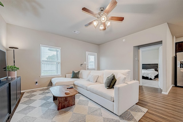 living room featuring ceiling fan and light hardwood / wood-style flooring