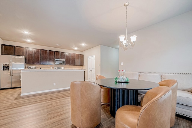 dining room featuring an inviting chandelier and light hardwood / wood-style flooring