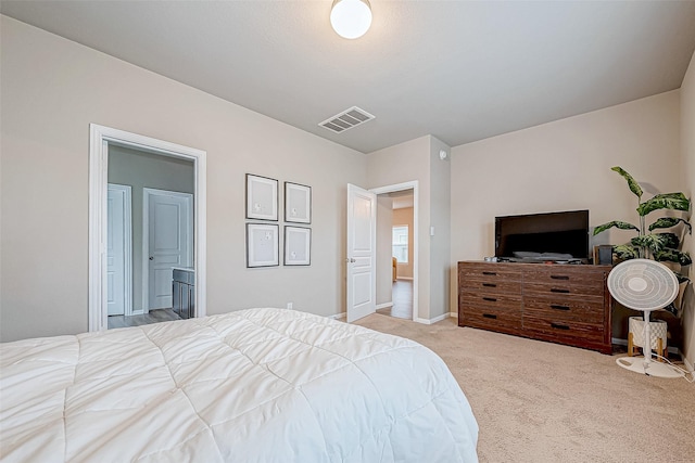 bedroom featuring connected bathroom and light carpet