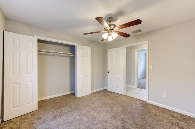 unfurnished bedroom with light colored carpet, a closet, and ceiling fan