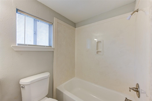 bathroom with bathtub / shower combination and toilet