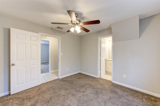 unfurnished bedroom with ceiling fan, light colored carpet, and ensuite bathroom