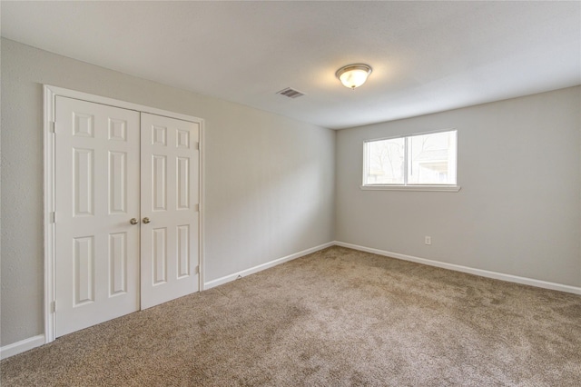 unfurnished bedroom featuring carpet floors and a closet