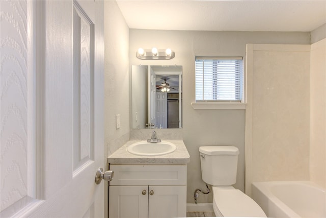 bathroom with vanity, a bath, toilet, and ceiling fan