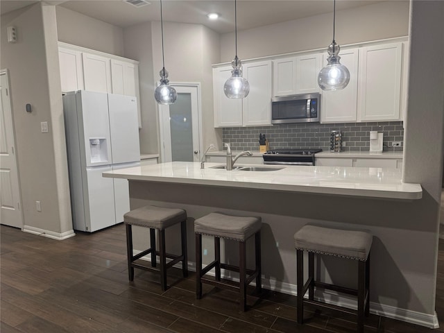 kitchen featuring stainless steel appliances, white cabinetry, sink, and tasteful backsplash