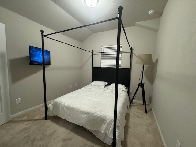 bedroom featuring lofted ceiling and light colored carpet