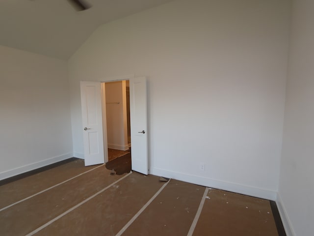 unfurnished bedroom with baseboards and lofted ceiling