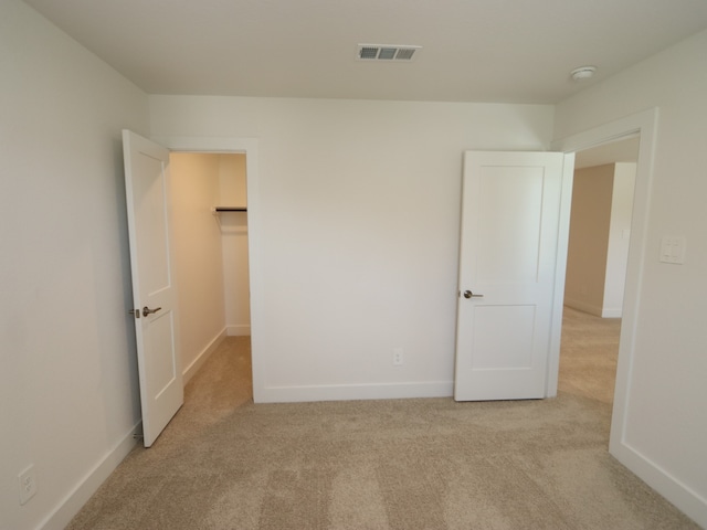 17322 Silver Birch Ct, New Caney, TX 77357 - unfurnished bedroom featuring light colored carpet, baseboards, and a walk in closet