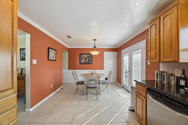 tiled dining space with ornamental molding, a textured ceiling, and french doors