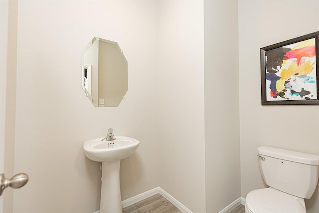 bathroom with hardwood / wood-style flooring and toilet