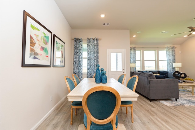 dining space with ceiling fan and light wood-type flooring