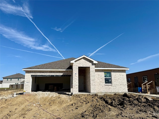 property in mid-construction featuring a shingled roof and an attached garage