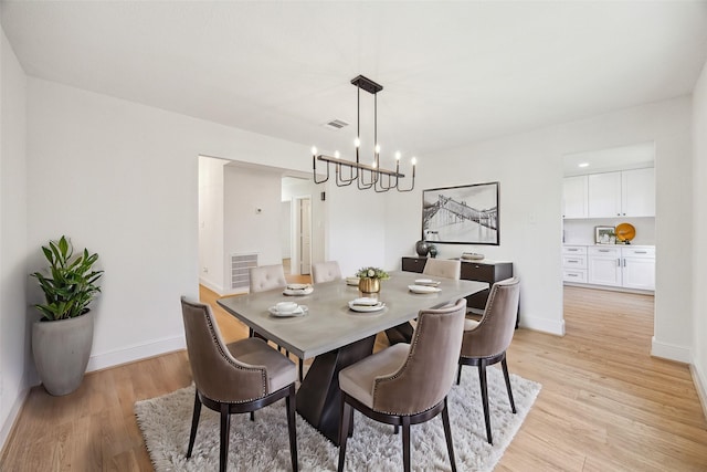 dining area featuring a chandelier and light hardwood / wood-style floors