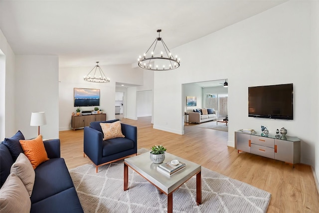 living room with high vaulted ceiling and light hardwood / wood-style flooring