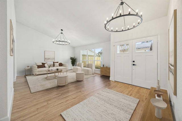 entrance foyer featuring lofted ceiling, a chandelier, and light hardwood / wood-style floors