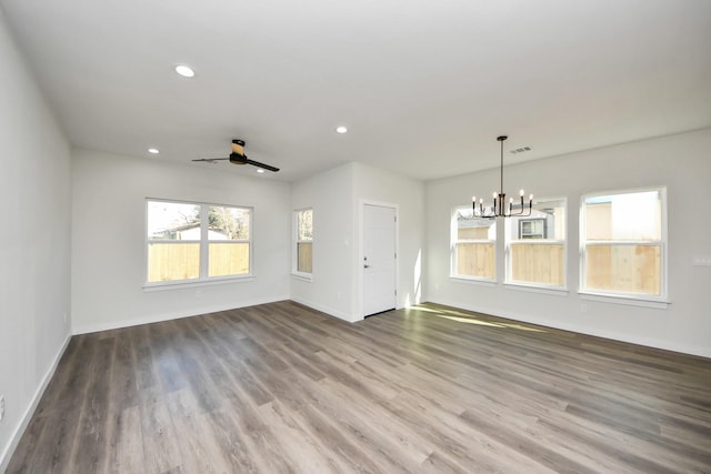 unfurnished room featuring ceiling fan with notable chandelier and wood-type flooring