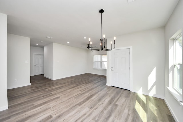 unfurnished dining area featuring a notable chandelier and light wood-type flooring