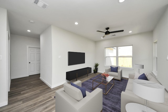 living room featuring dark wood-type flooring and ceiling fan