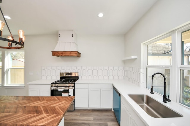 kitchen with white cabinetry, appliances with stainless steel finishes, a chandelier, and sink