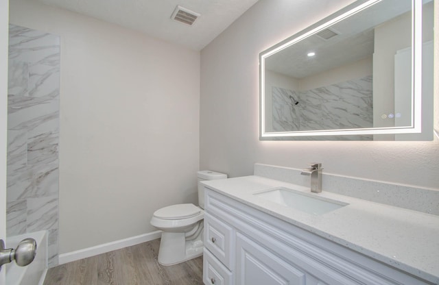 bathroom featuring vanity, hardwood / wood-style floors, and toilet