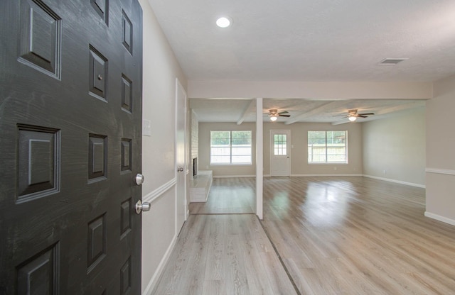 entrance foyer featuring beamed ceiling, ceiling fan, and light wood-type flooring