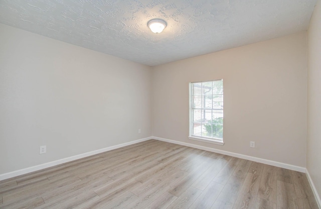 spare room featuring a textured ceiling and light wood-type flooring