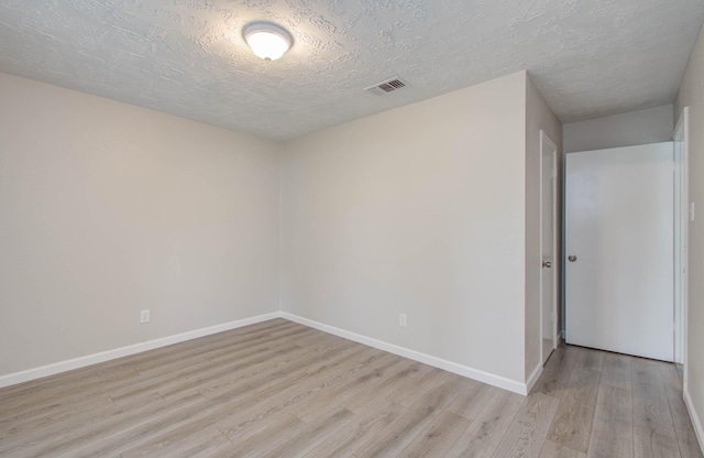 empty room featuring light hardwood / wood-style flooring and a textured ceiling