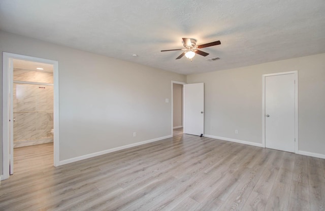 empty room with a textured ceiling, light hardwood / wood-style flooring, and ceiling fan