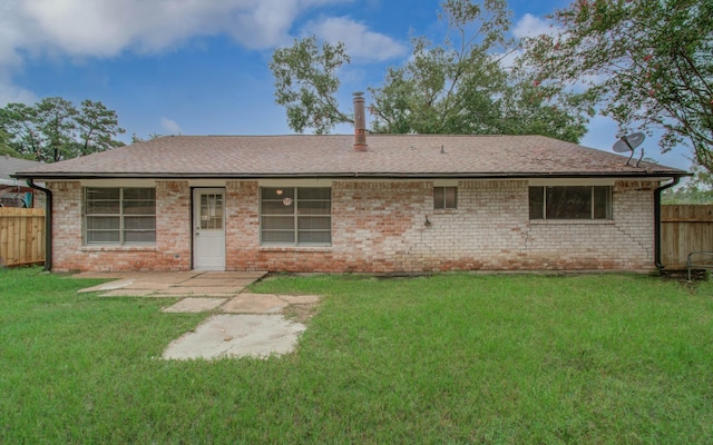 rear view of property with a yard