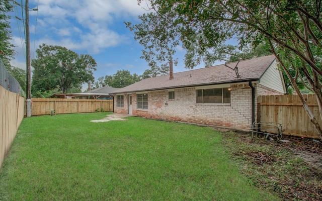 rear view of house featuring a yard