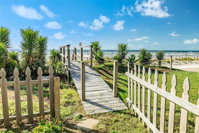 view of home's community featuring a water view and a beach view