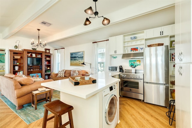 kitchen with washer / dryer, an inviting chandelier, white cabinetry, decorative light fixtures, and appliances with stainless steel finishes