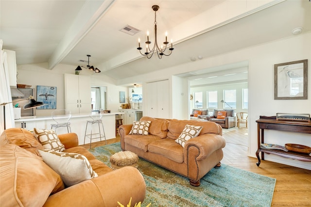 living room featuring lofted ceiling with beams, light parquet flooring, and a notable chandelier