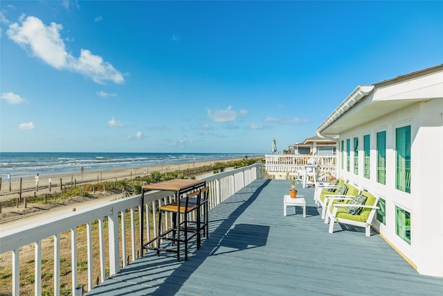 deck with a beach view and a water view