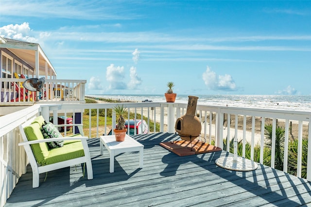 deck with a water view and a beach view