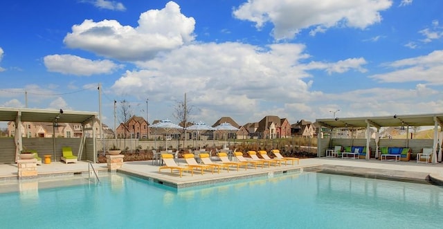 community pool with ceiling fan, fence, and a patio