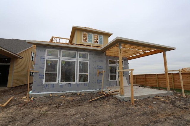 rear view of house with a patio area and fence