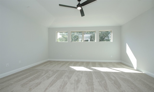 unfurnished room with vaulted ceiling, light colored carpet, and ceiling fan