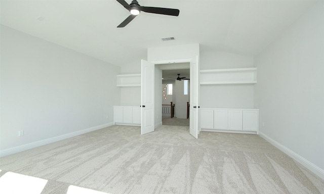 interior space with lofted ceiling, light colored carpet, and ceiling fan