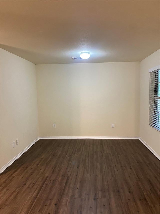 unfurnished room featuring dark wood-type flooring