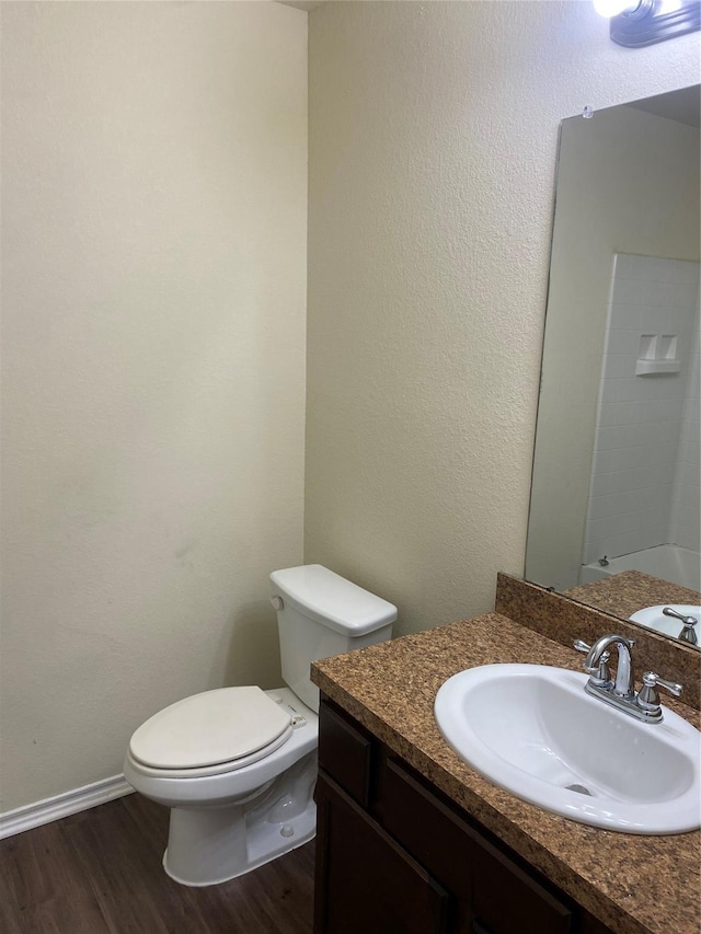 bathroom with hardwood / wood-style flooring, vanity, and toilet