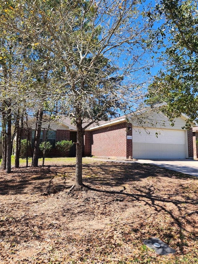 ranch-style home with a garage, concrete driveway, and brick siding