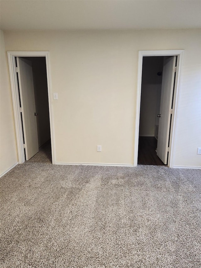 spare room with baseboards and carpet flooring