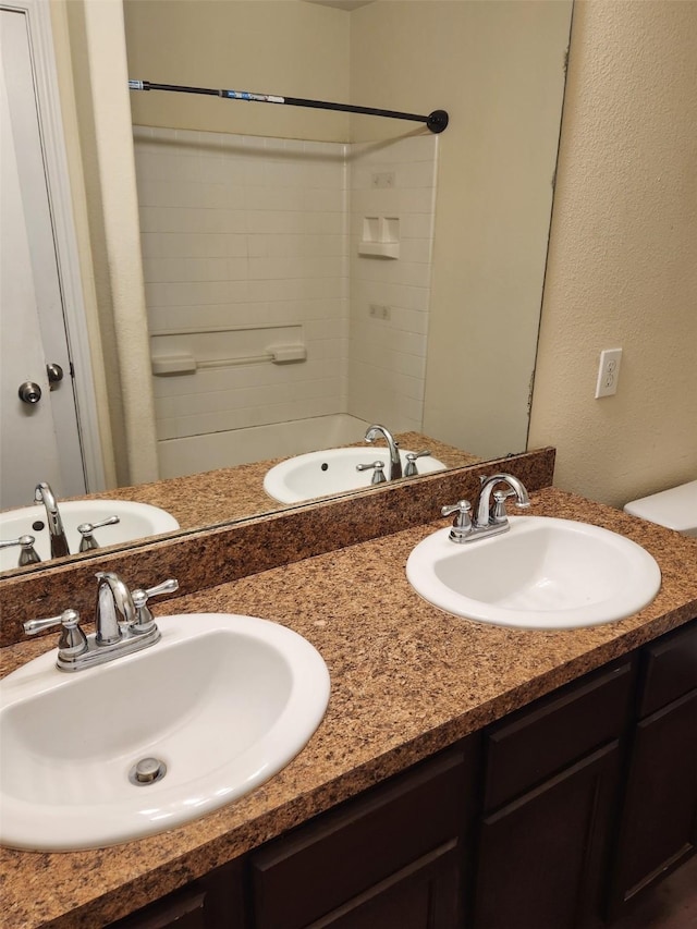 bathroom featuring double vanity, a sink, and walk in shower