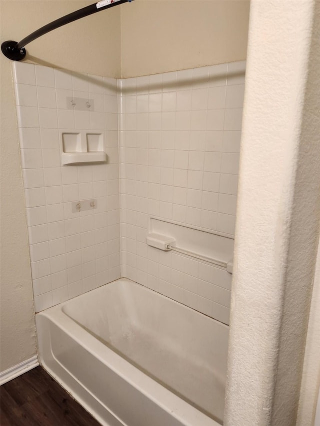 bathroom with wood finished floors, shower / tub combination, and baseboards