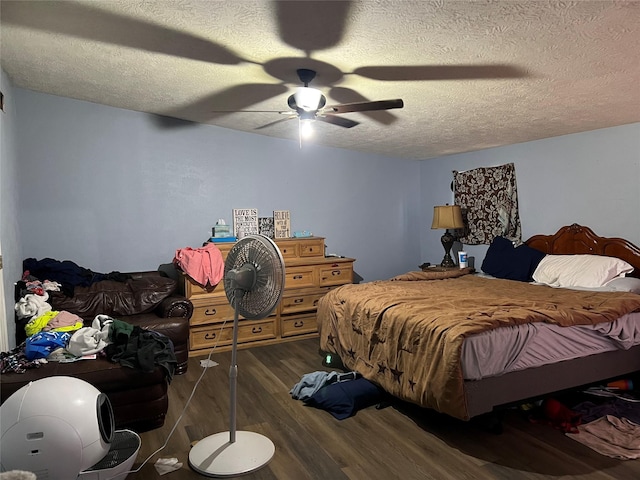 bedroom featuring ceiling fan, dark hardwood / wood-style floors, and a textured ceiling