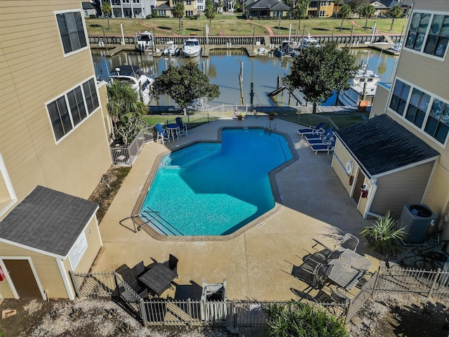 view of swimming pool featuring central AC, a patio, a storage unit, and a water view