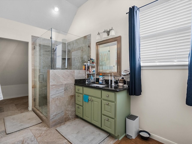 bathroom featuring walk in shower, lofted ceiling, and vanity