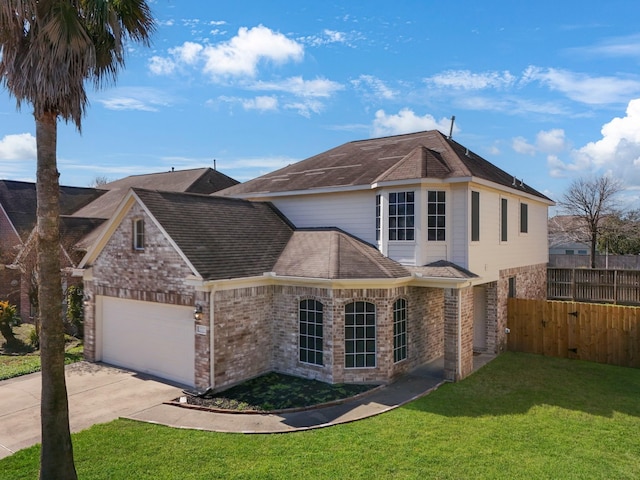 traditional-style house featuring driveway, brick siding, a front yard, and fence